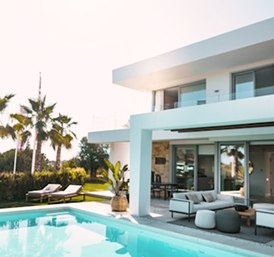 Casa branca com piscina e palmeiras